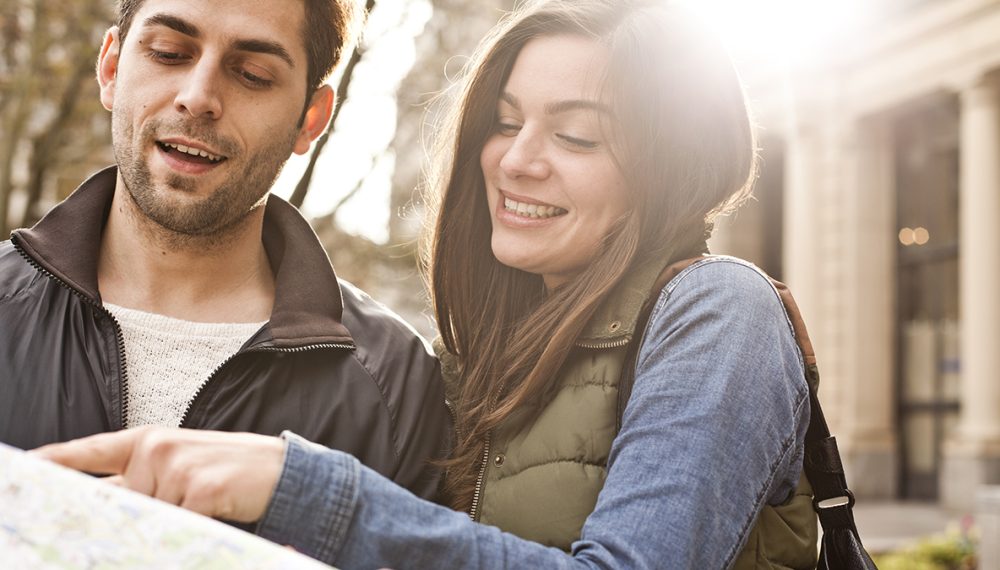 Young couple looking at map, planning their life together